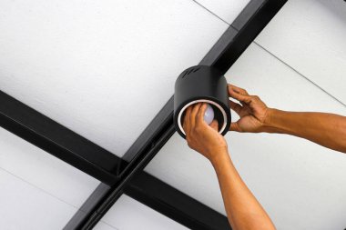 Tavana ışık tutan bir elektrikçinin elleri..