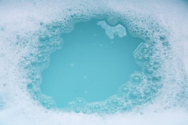 Deterjan köpüklü su. Mavi arkaplan, sabun suyu