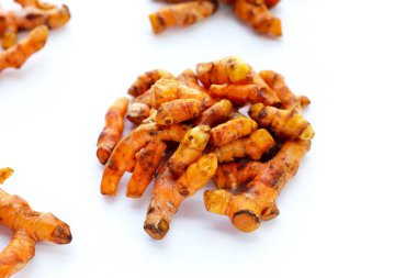 Beyaz arkaplanda zerdeçal kökleri.