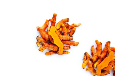 Beyaz arkaplanda zerdeçal kökleri.