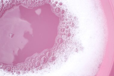 Beyaz deterjan köpüğü, pembe arka plan..