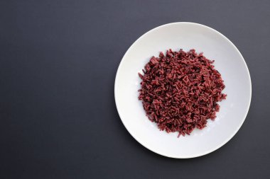 Koyu arkaplanda siyah pirinç pişirilmiş..