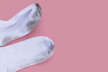 Pembe arka planda kirli beyaz çoraplar.