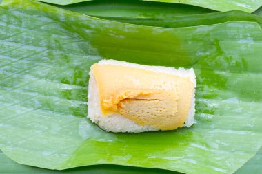 Muz yaprakları üzerinde yumurta kremalı tatlı pilav.