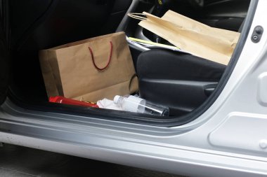 Eşyalarla dolu arabada, plastik torbalar, plastik su şişeleri, evrak dosyaları, kağıt torbalar, kağıt mendil..
