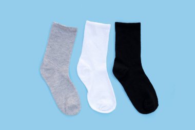 Mavi arka planda gri, beyaz ve siyah çoraplar.