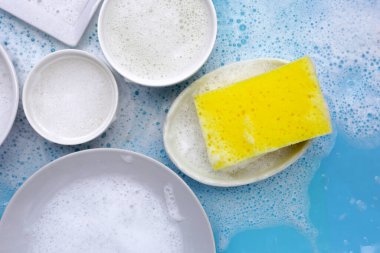 Bulaşık deterjanı köpüklü temizlik süngeri ile kase. Bulaşık yıkama kavramı