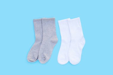 Mavi arka planda gri ve beyaz çoraplar.