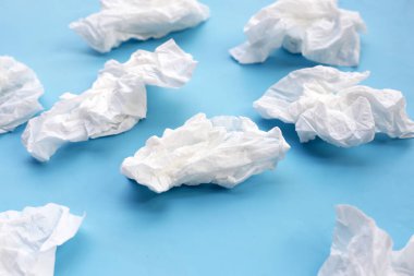 Buruşmuş kağıt mendil. Mavi arka planda yüz dokusu.