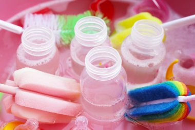 Bebek şişelerini plastik pembe leğende yıka.
