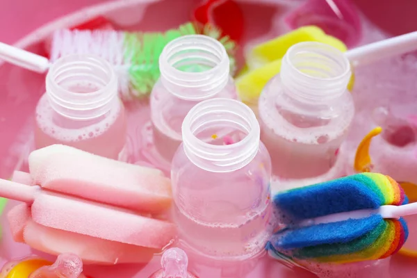 Bebek şişelerini plastik pembe leğende yıka.