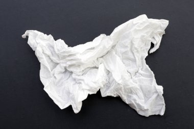 Buruşmuş kağıt mendil. Koyu arkaplanda yüz dokusu.