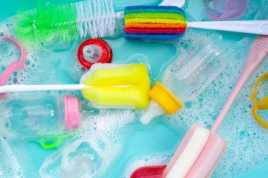 Bebek şişelerini plastik mavi leğende yıka.