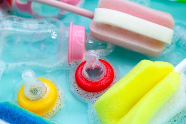 Bebek şişelerini plastik mavi leğende yıka.