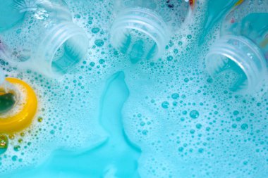 Bebek şişelerini plastik mavi leğende yıka.