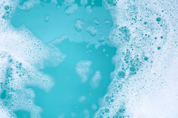 Deterjan köpüklü su. Mavi arkaplan, sabun suyu