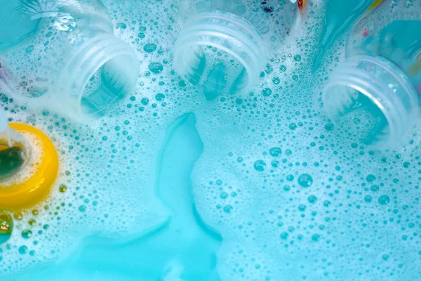 Bebek şişelerini plastik mavi leğende yıka.