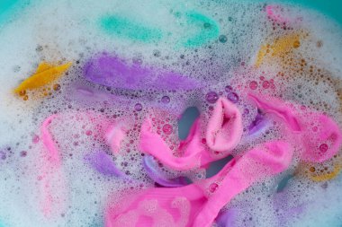 Kirli çoraplar suya batırılmış, deterjanı leğende eritiyor..