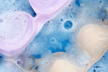 Beyaz köpüklü, çözünmüş deterjana batırılmış kadın sütyeni. Çamaşır konsepti