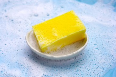 Bulaşık deterjanı köpüklü temizlik süngeri ile kase. Bulaşık yıkama kavramı