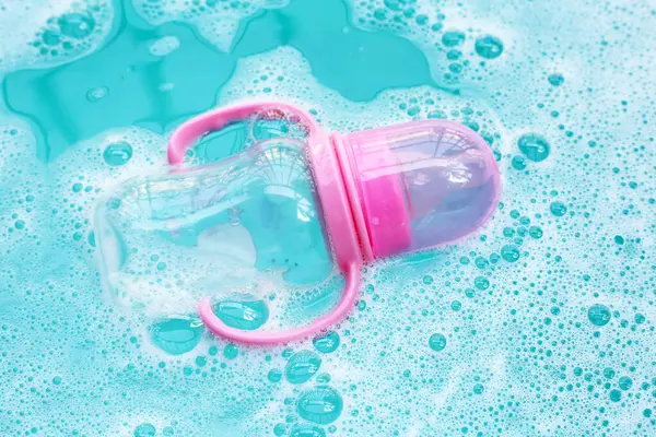 Sterilizing baby bottle in plastic blue basin