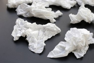 Buruşmuş kağıt mendil. Koyu arkaplanda yüz dokusu.