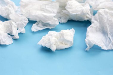 Buruşmuş kağıt mendil. Mavi arka planda yüz dokusu.