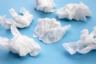 Buruşmuş kağıt mendil. Mavi arka planda yüz dokusu.