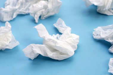 Buruşmuş kağıt mendil. Mavi arka planda yüz dokusu.