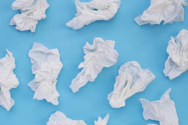 Buruşmuş kağıt mendil. Mavi arka planda yüz dokusu.