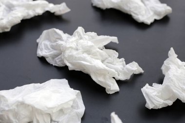 Buruşmuş kağıt mendil. Koyu arkaplanda yüz dokusu.