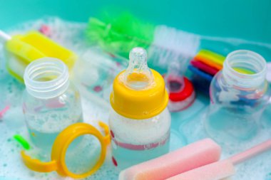 Bebek şişelerini plastik mavi leğende yıka.