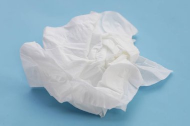 Buruşmuş kağıt mendil. Mavi arka planda yüz dokusu.