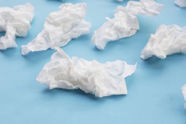 Buruşmuş kağıt mendil. Mavi arka planda yüz dokusu.