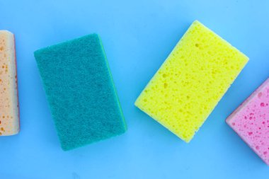 Mavi arka planda bulaşık yıkama süngeri..