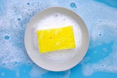 Bulaşık deterjanı köpüklü temizlik süngeri. Bulaşık yıkama kavramı