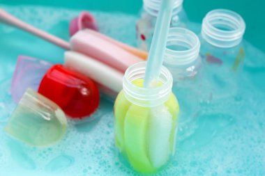 Bebek şişelerini plastik mavi leğende yıka.