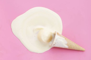 Pembe arka planda waffle külahlı dondurma topları eritiliyor.