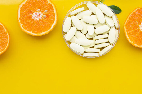 Витамин С таблетки со свежими апельсиновыми цитрусовыми фруктами на белом фоне
.