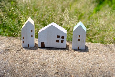 Yeşil çimlerin üzerindeki minyatür ahşap ev