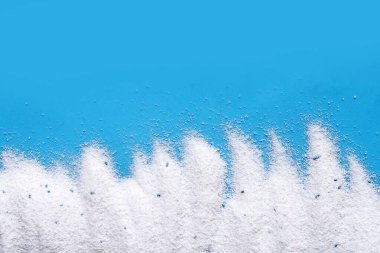 Detergent powder on blue background. Laundry concept.