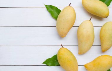 Tropik meyve, beyaz ahşap arka planda mango..