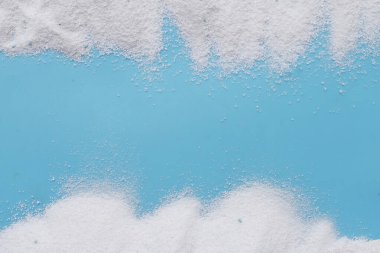 Detergent powder on blue background. Laundry concept.