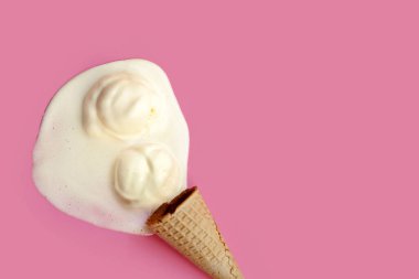Pembe arka planda waffle külahı olan erimiş dondurma topu..