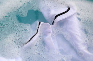 Toz deterjana batırılmış beyaz bez deterjan çözeltisi, bez. Çamaşır konsepti