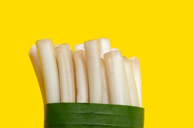 Sarı zemin üzerinde taze nilüfer kökü.