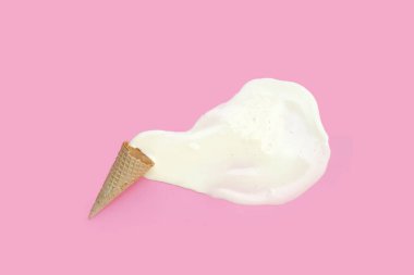 Pembe arka planda waffle külahı olan erimiş dondurma topu..