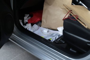 Eşyalarla dolu arabada, plastik torbalar, plastik su şişeleri, evrak dosyaları, kağıt torbalar, kağıt mendil..