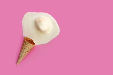 Pembe arka planda waffle külahı olan erimiş dondurma topu..