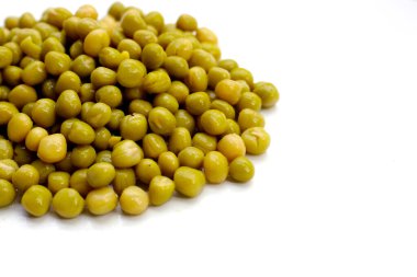 Beyaz zemin üzerinde konserve yeşil bezelyeler.